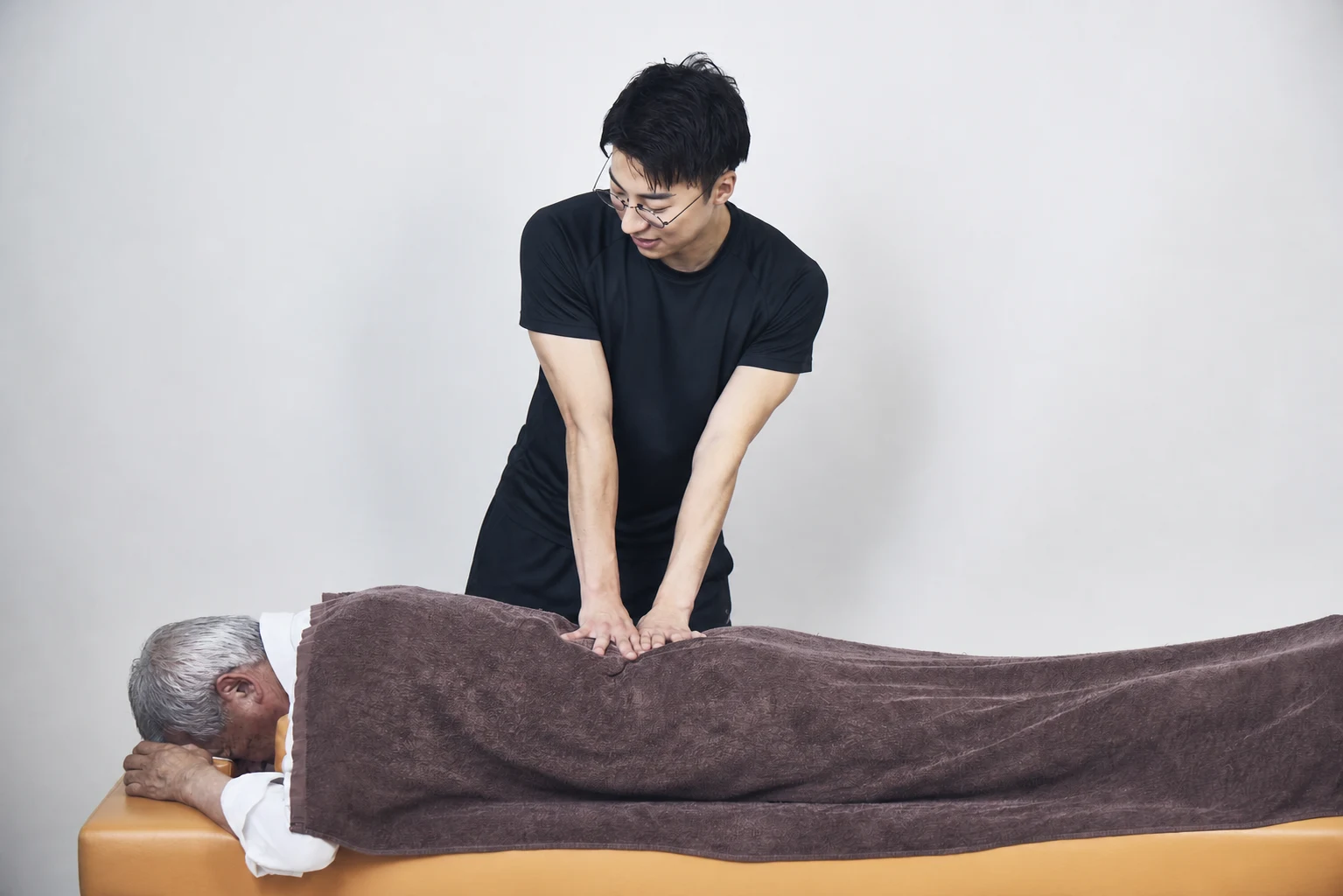 パーソナルトレーナーが利用者へ整体セッションを行う様子